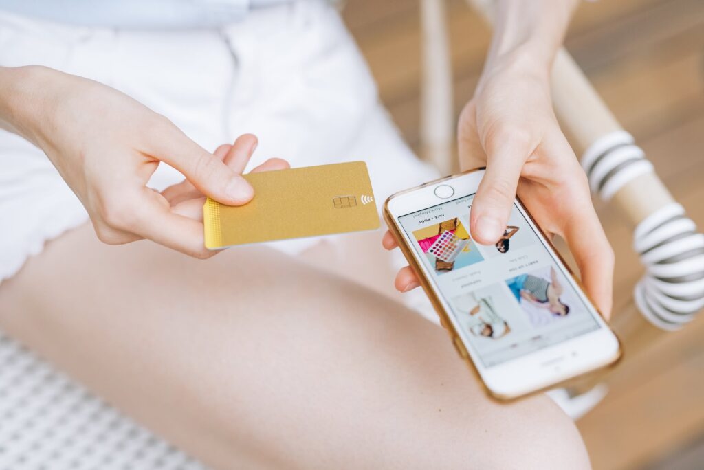 Mulher branca realizando compra online com cartão de crédito